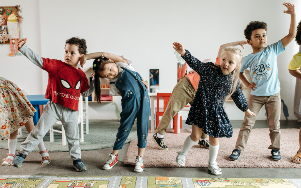 A few children exercising in a kindergarten classroom