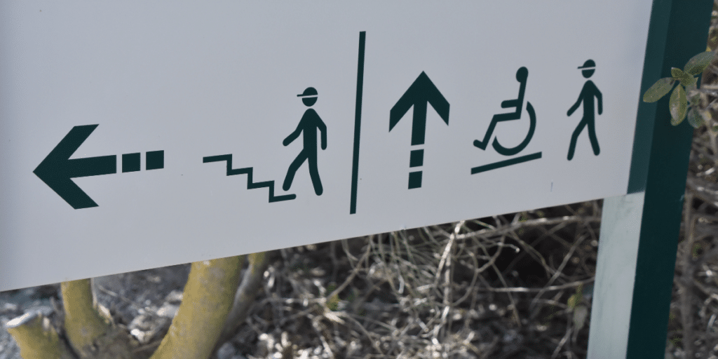 Signboard with directions for people that can climb stairs and alternative adjustments for those with disability.